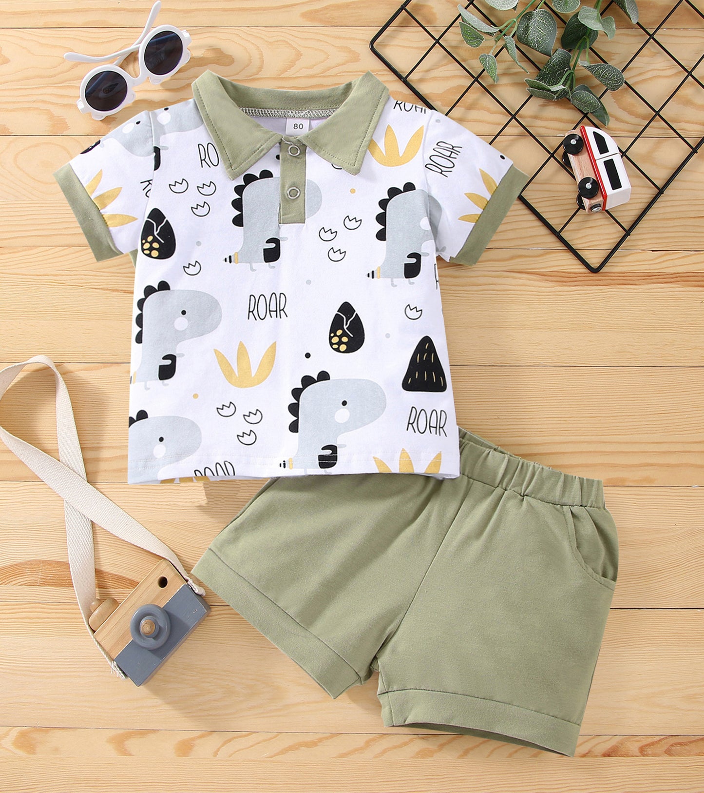 Conjunto de calções de manga curta com estampado animal e gola polo para menino, perfeito para atividades ao ar livre.