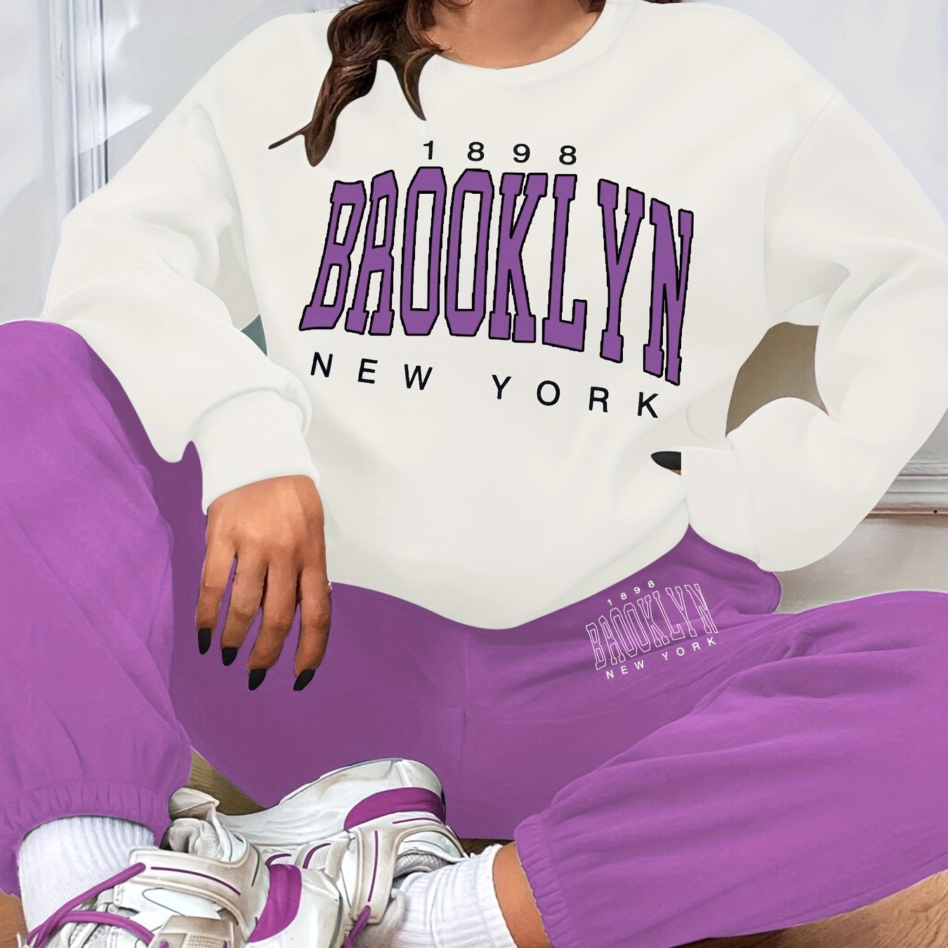 Conjunto casual de duas peças com blocos de cor, composto por uma sweatshirt com estampado de letras e calças jogger desportivas. Roupas femininas.