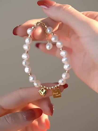 Elegante pulseira feminina com contas douradas e pendente de coração. Uma joia perfeita para o dia a dia e para ocasiões especiais, como o Dia dos Namorados, aniversários e outras datas comemorativas. Um acessório de luxo para usar durante todo o ano.