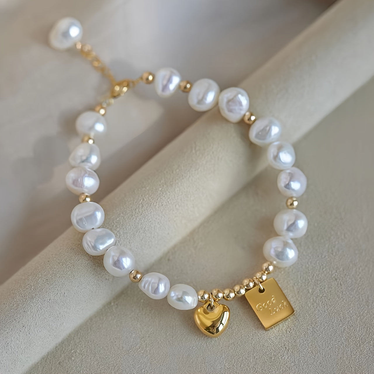 Elegante pulseira feminina com contas douradas e pendente de coração. Uma joia perfeita para o dia a dia e para ocasiões especiais, como o Dia dos Namorados, aniversários e outras datas comemorativas. Um acessório de luxo para usar durante todo o ano.