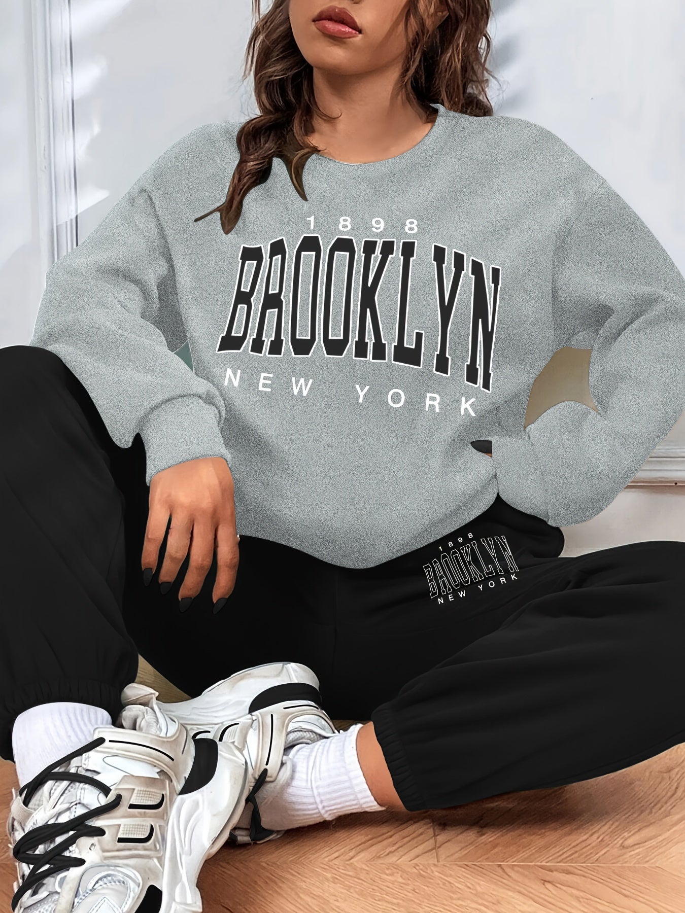 Conjunto casual de duas peças com blocos de cor, composto por uma sweatshirt com estampado de letras e calças jogger desportivas. Roupas femininas.