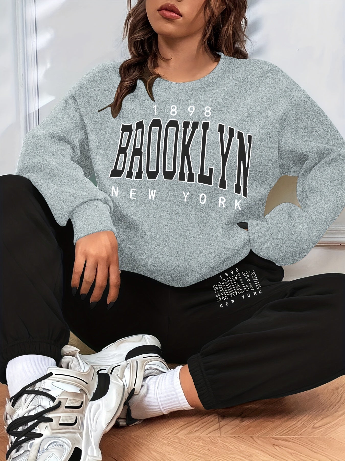 Conjunto casual de duas peças com blocos de cor, composto por uma sweatshirt com estampado de letras e calças jogger desportivas. Roupas femininas.