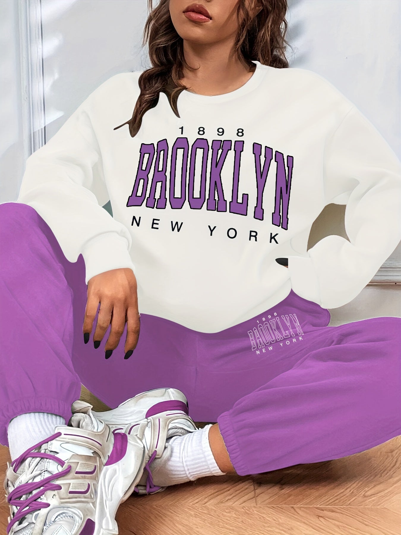 Conjunto casual de duas peças com blocos de cor, composto por uma sweatshirt com estampado de letras e calças jogger desportivas. Roupas femininas.
