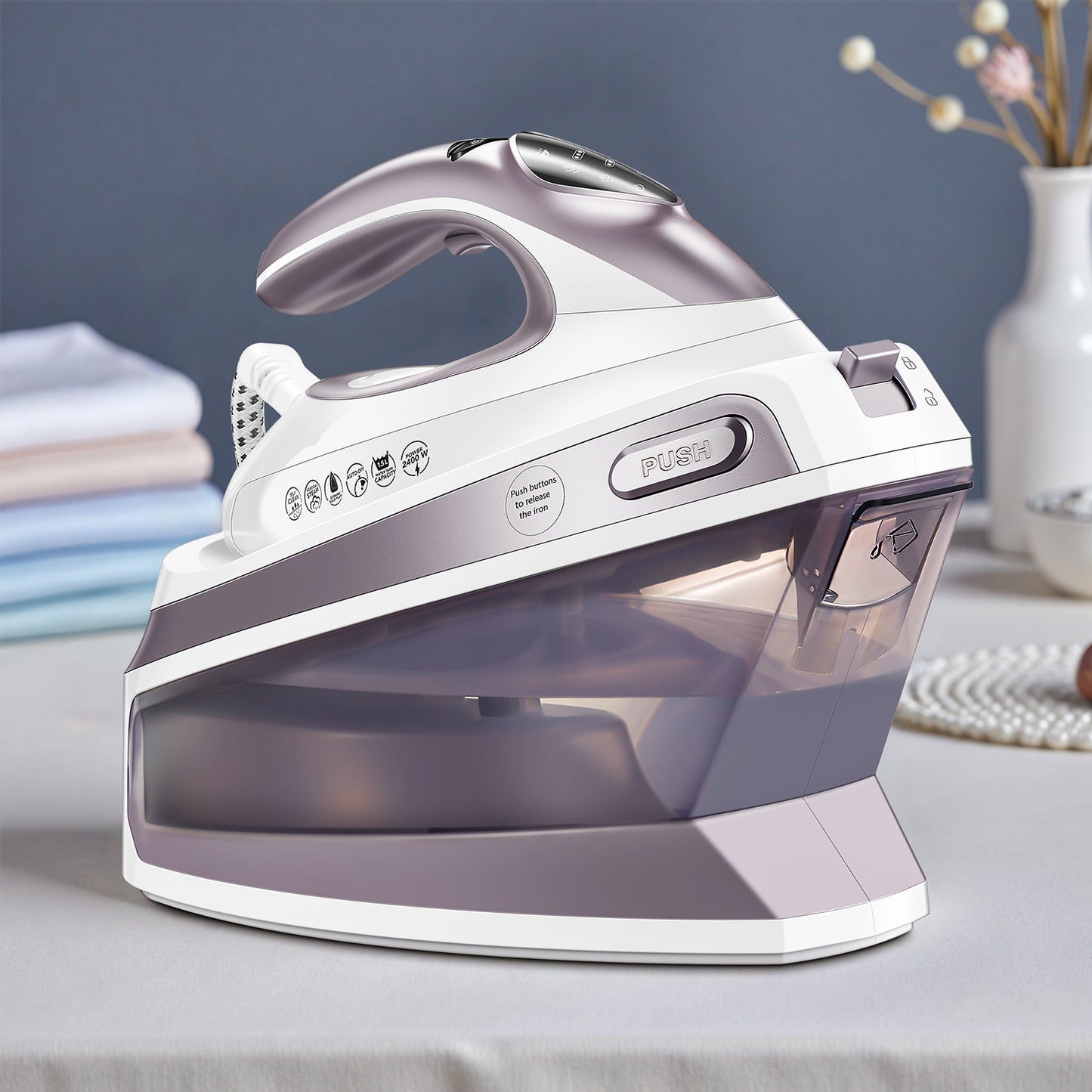 Steam Station Iron Offers 5.5 Bar Pressure, a 1.5L Water Tank, Ceramic Soleplate, Anti-Limescale Function, Vertical Steaming, Three Temperature Settings, Cord Storage, And 2400W Power. Available in Light Purple.
