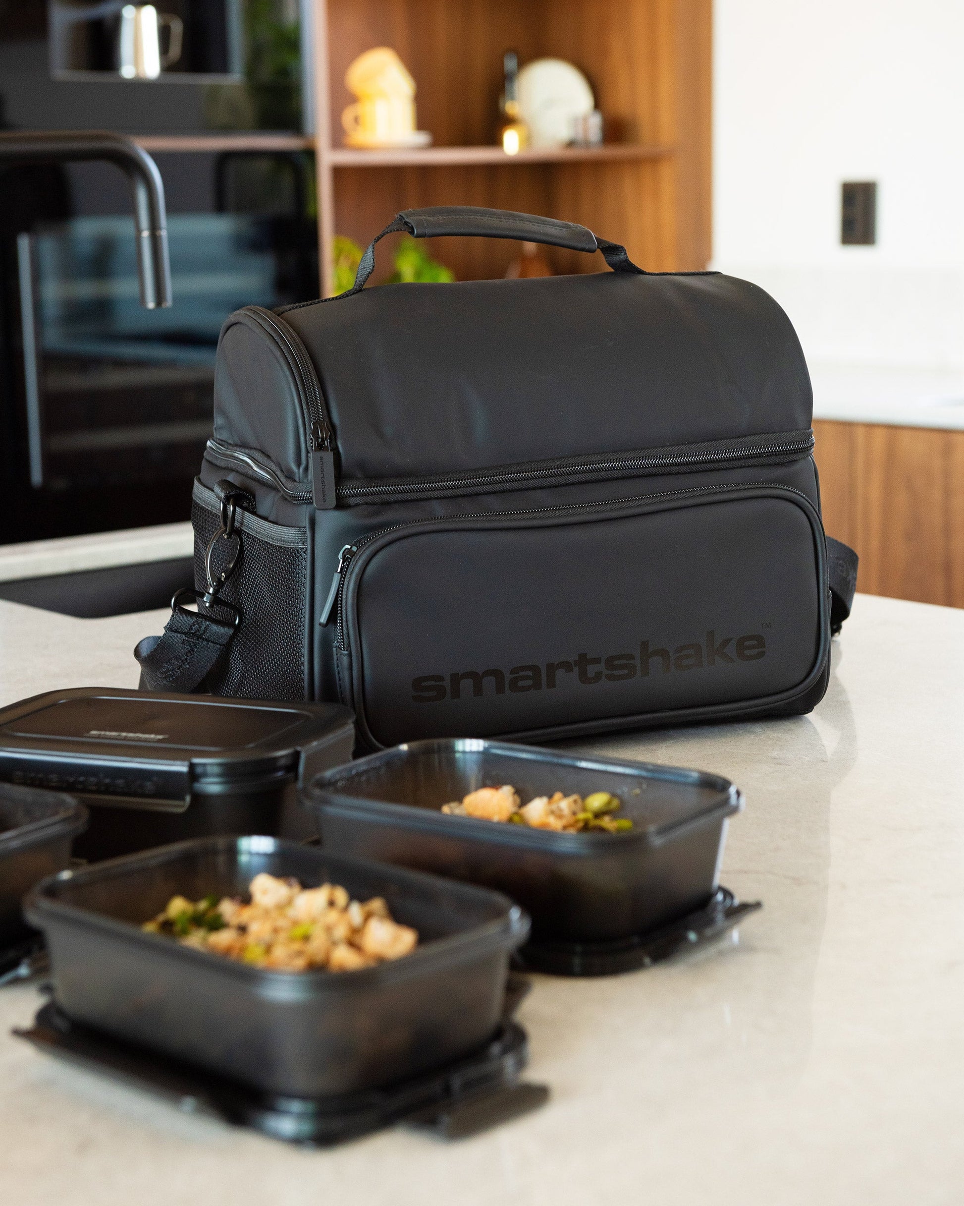 https://ik.imagekit.io/c2dr4dawp/https%3A%2F%2Fcdn.shopify.com%2Fs%2Ffiles%2F1%2F0484%2F7091%2F7273%2Ffiles%2FSmartshake_Meal_Prep_Bag_Black_liefstyle.jpg%3Fv%3D1777449034?tr=f-jpg